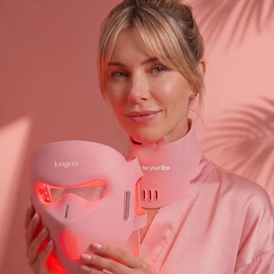 Blonde woman holding the illuminated Longera AVA LED face and neck mask